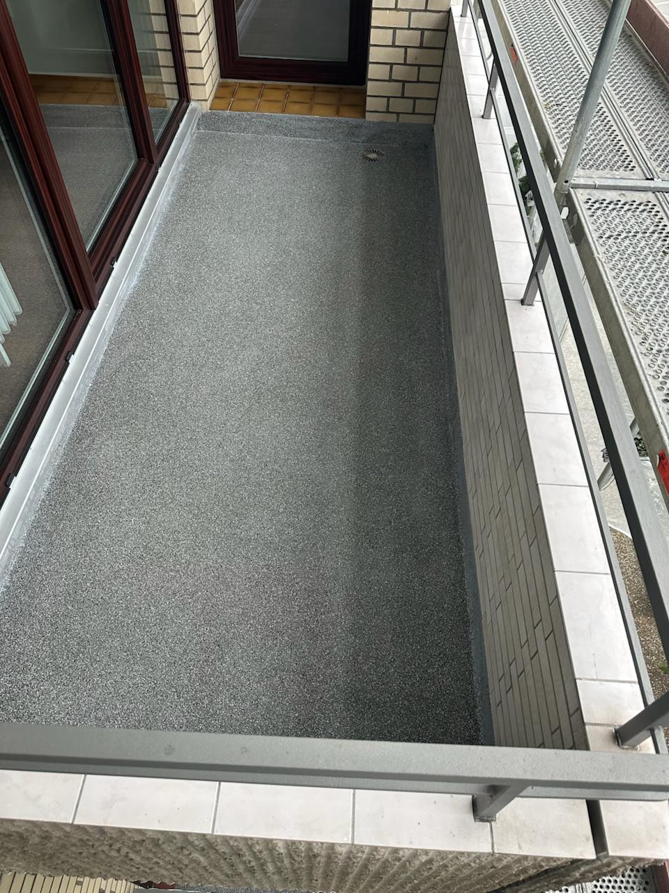 Balkon mit neuem, gleichmäßigem Bodenbelag nach der Sanierung